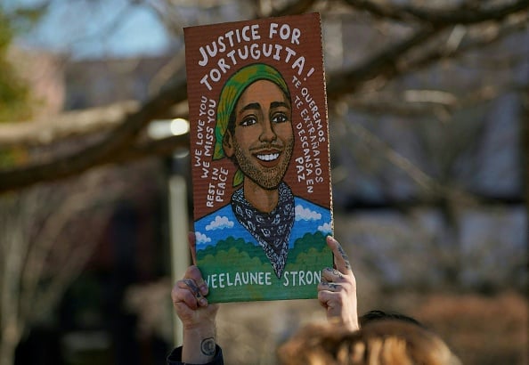 A mourner holds a painting of environmental activist Manuel Téran, who was killed by law enforcement during a raid to clear the construction site of a public safety training facility that activists have nicknamed "Cop City", during a press conference in Decatur, Georgia on February 6, 2023. (Photo by CHENEY ORR / AFP) (Photo by CHENEY ORR/AFP via Getty Images)