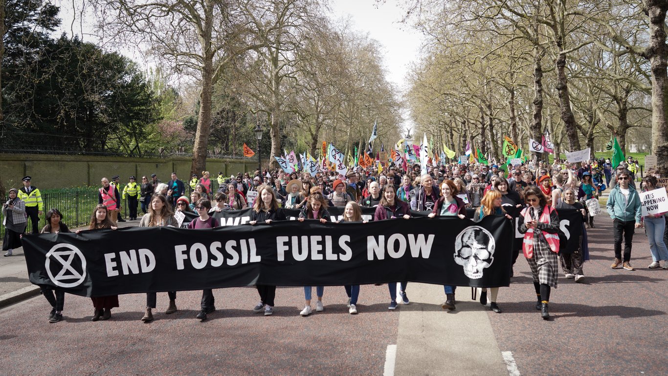 Extinction Rebellion supporters march down Constitution Hill towards Buckingham Palace and the River Thames in April 2022. Credit: Alisdare Hickson /Top photo: Activists protest the Police, Crime and Sentencing Bill in January 2022/ Credit: Alisdare Hickson