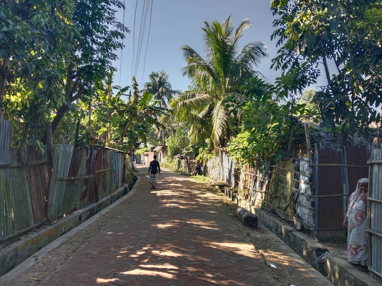 A women observes visitors to her village in Moheshkhali. Photo by: Rishika Pardikar