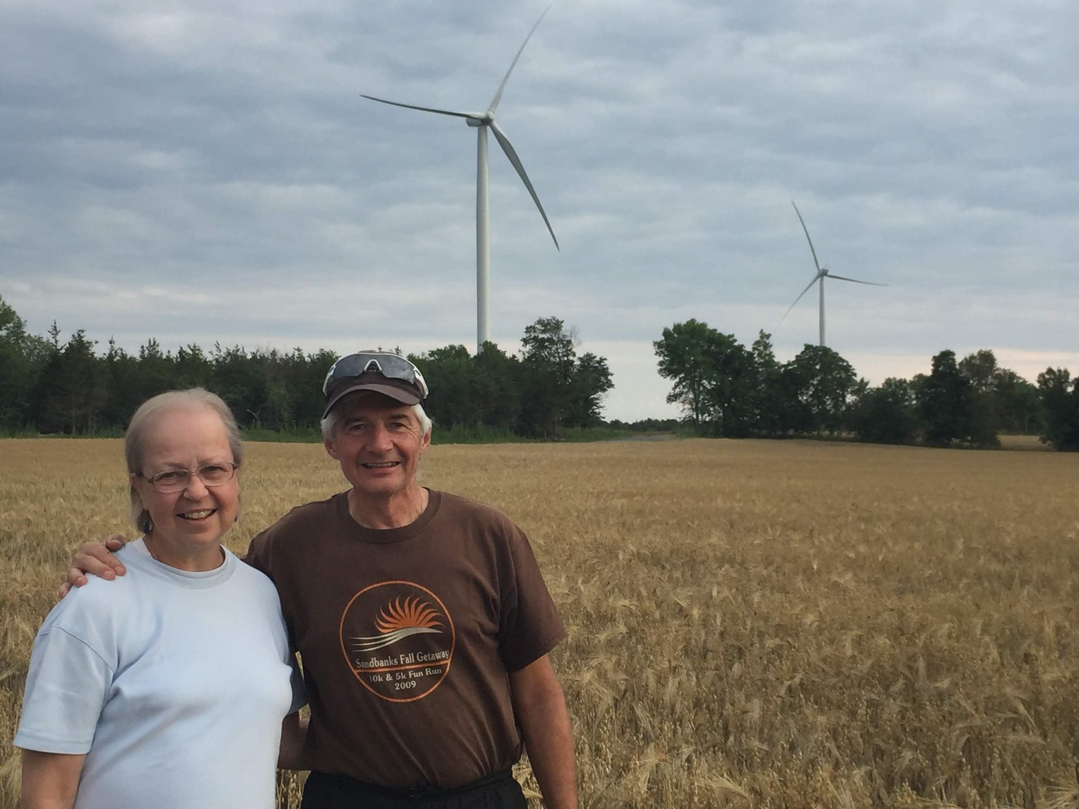 Don and Heather Ross in front of turbines near their home. Photo courtesy Don Ross.